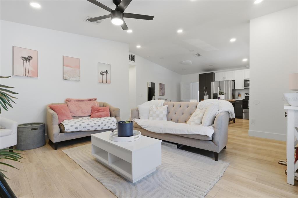 A living room with two sofas, a white coffee table, and an open kitchen — 1918 W PINE STREET, TAMPA, FL