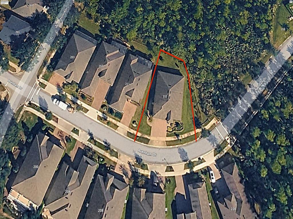 An aerial view shows a residential property lot outlined in red on a suburban street — 215 AVENHAM DRIVE, DELAND, FL