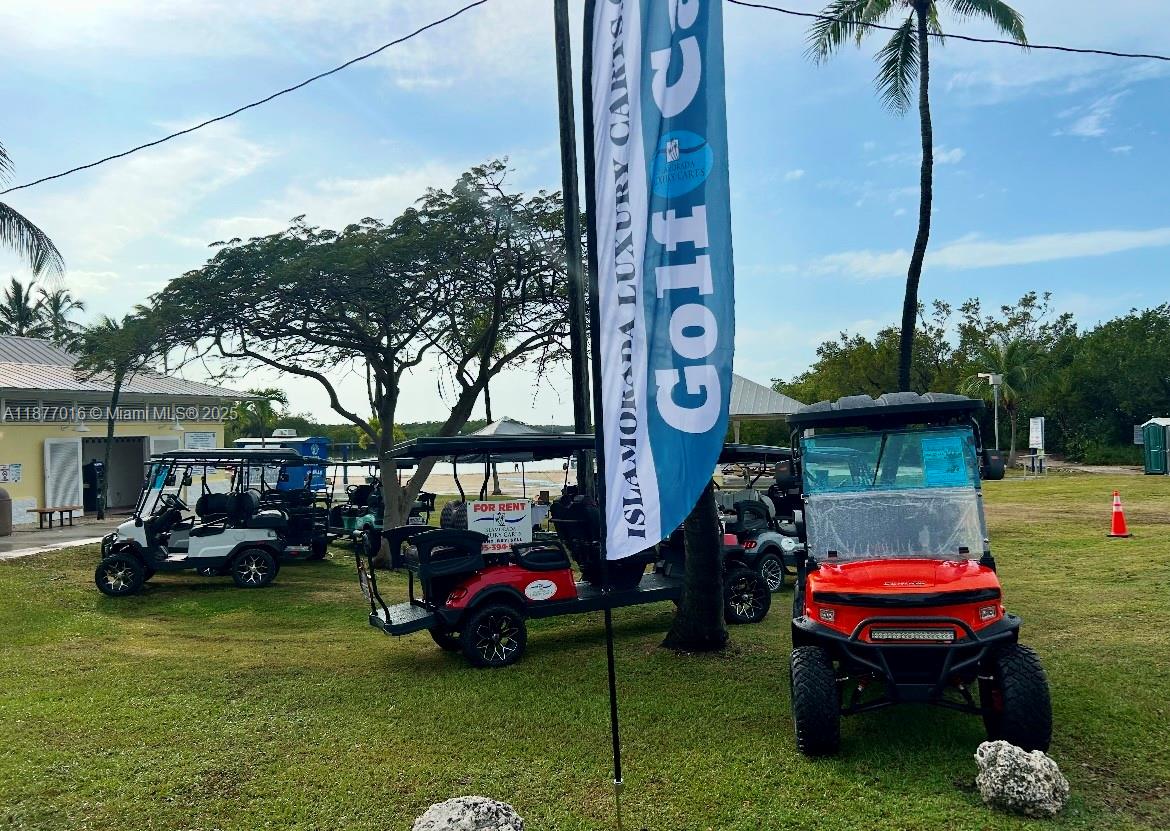 Several golf carts are parked on a grassy area near a beach and trees — 0000 Overseas Highway, Islamorada FL 33036, ISLAMORADA, FL
