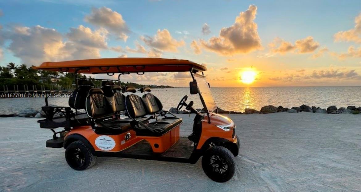 An orange golf cart is parked on a sandy beach at sunset near the ocean — 0000 Overseas Highway, Islamorada FL 33036, ISLAMORADA, FL
