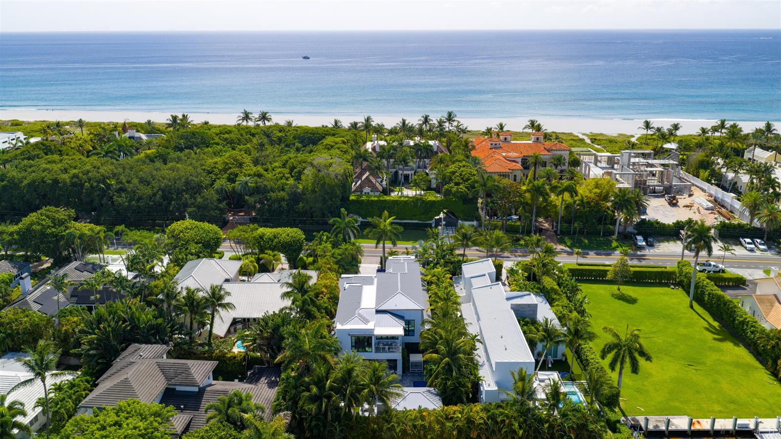 An aerial view shows luxury coastal homes surrounded by lush tropical landscaping near the ocean — 1040 S Ocean Boulevard, Delray Beach FL 33483, DELRAY BEACH, FL