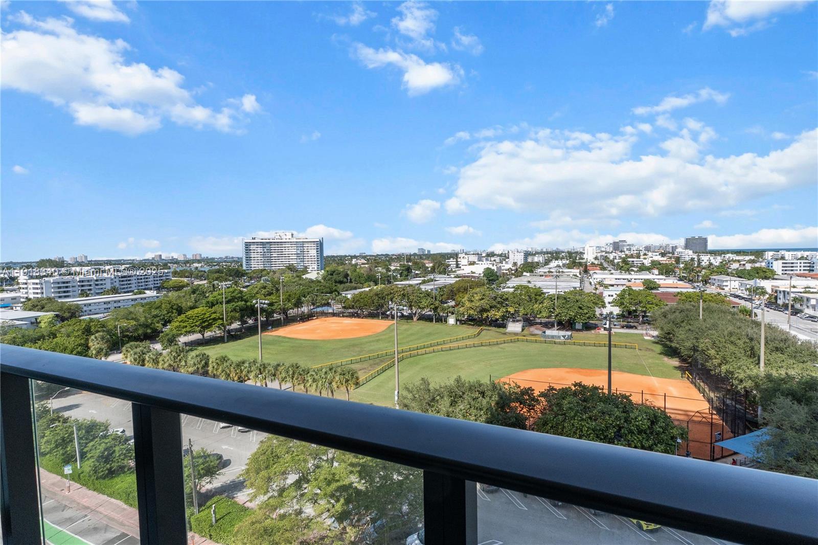 An elevated view from a balcony overlooking a public park with two baseball fields — 580 72nd # 711, Miami Beach FL 33141, MIAMI BEACH, FL