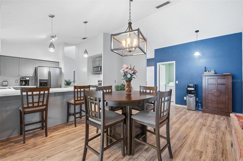 A dining area with a wooden table and chairs sits adjacent to a kitchen island — 22 FORDHAM LANE, PALM COAST, FL