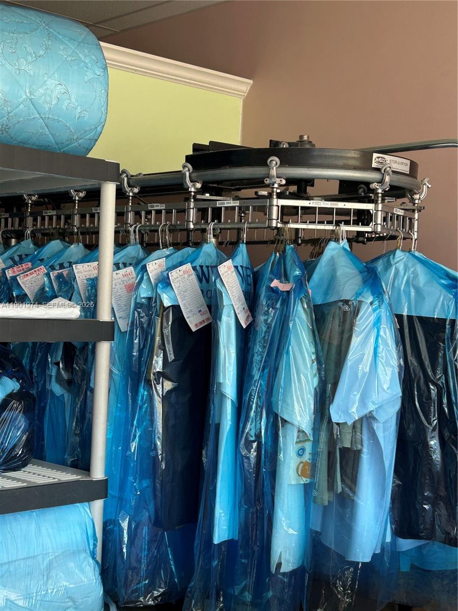 A dry cleaning conveyor system holds rows of garments protected by plastic covers — 0 W 24th Ave, Hialeah FL 33016, HIALEAH, FL