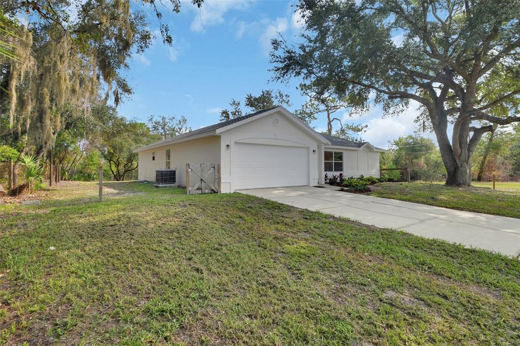 A single-story house with a white exterior, a two-car garage, and a concrete driveway — 1251 SEMINOLE DRIVE, DE LEON SPRINGS, FL
