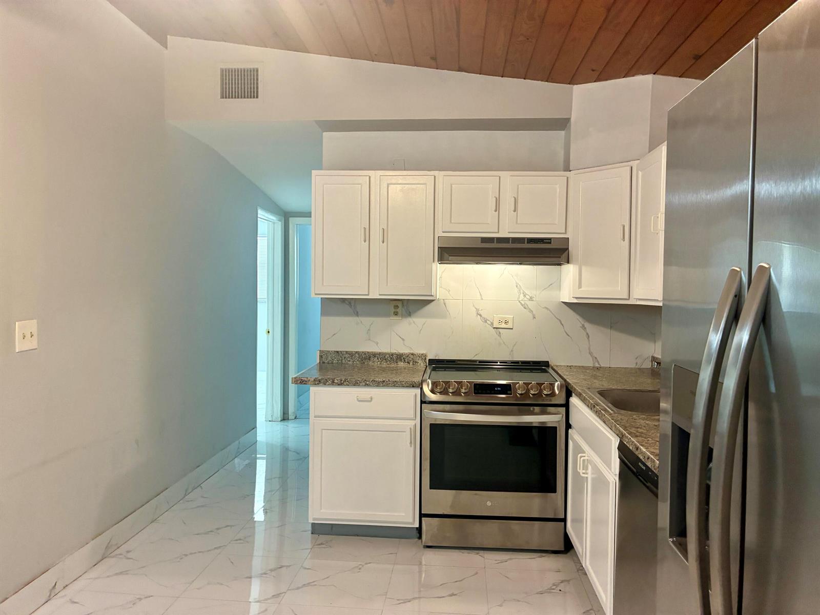 A kitchen features white cabinets, stainless steel appliances, granite countertops, and white marble-patterned tile flooring — 3630 SW 46th Avenue, West Park FL 33023, WEST PARK, FL