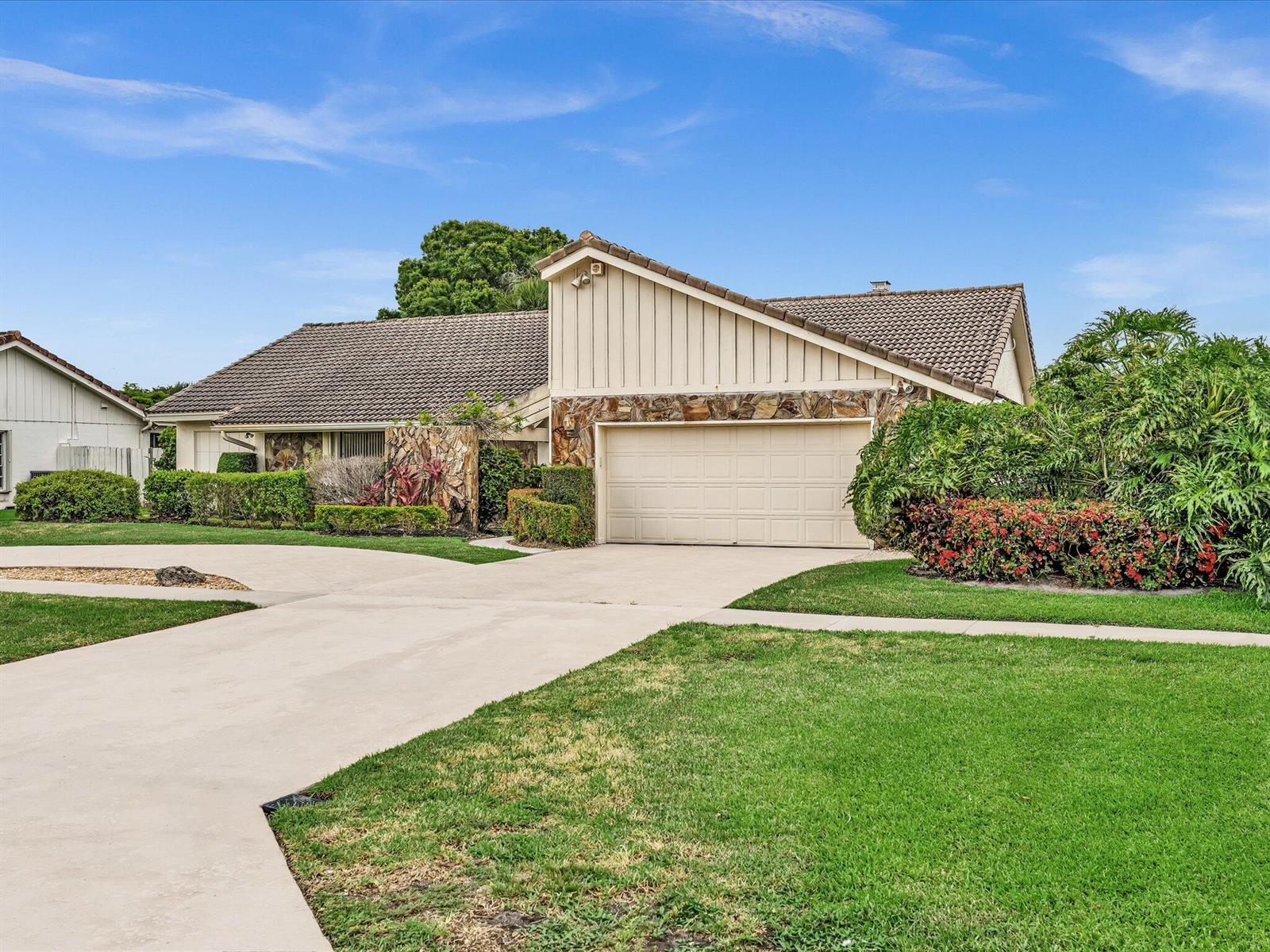 A single-story house with a beige garage, stone accents, and a tiled roof — 5302 Piping Rock Drive, Boynton Beach FL 33437, BOYNTON BEACH, FL