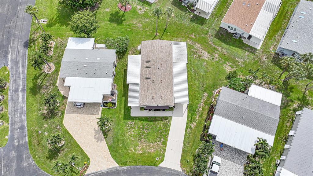 An aerial view shows three manufactured homes with driveways and landscaping in a residential community — 16209 ASHEBORO COURT, FORT MYERS, FL