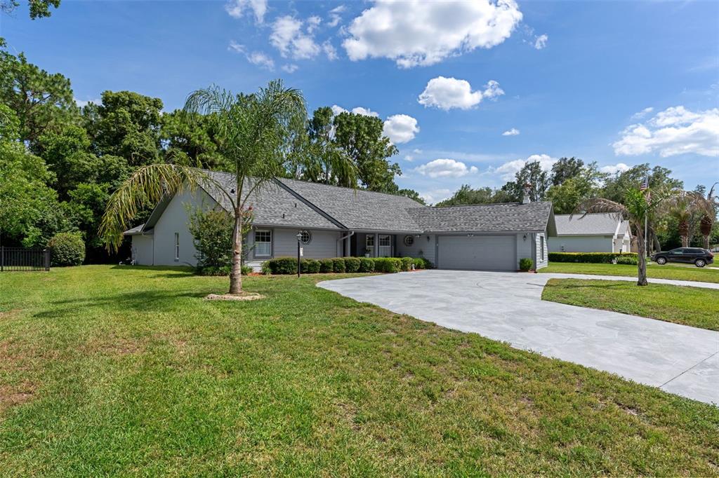 An indoor sunroom features a large, octagonal tiled spa surrounded by windows overlooking trees — 43 LINDER CIRCLE, HOMOSASSA, FL
