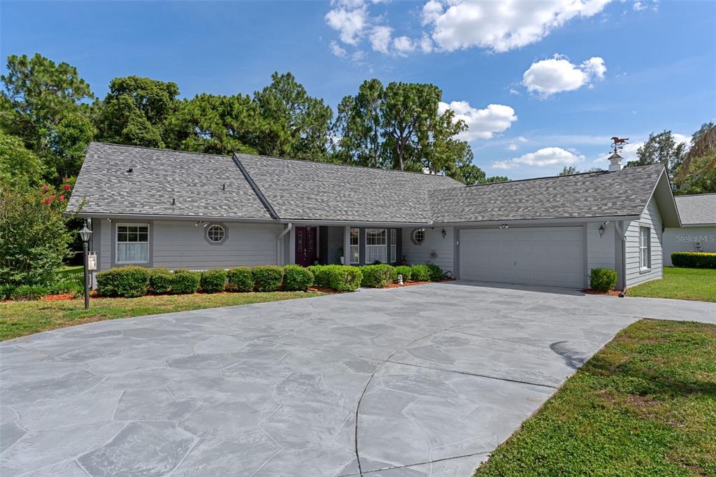 A single-story gray house with a large concrete driveway and a palm tree in front — 43 LINDER CIRCLE, HOMOSASSA, FL