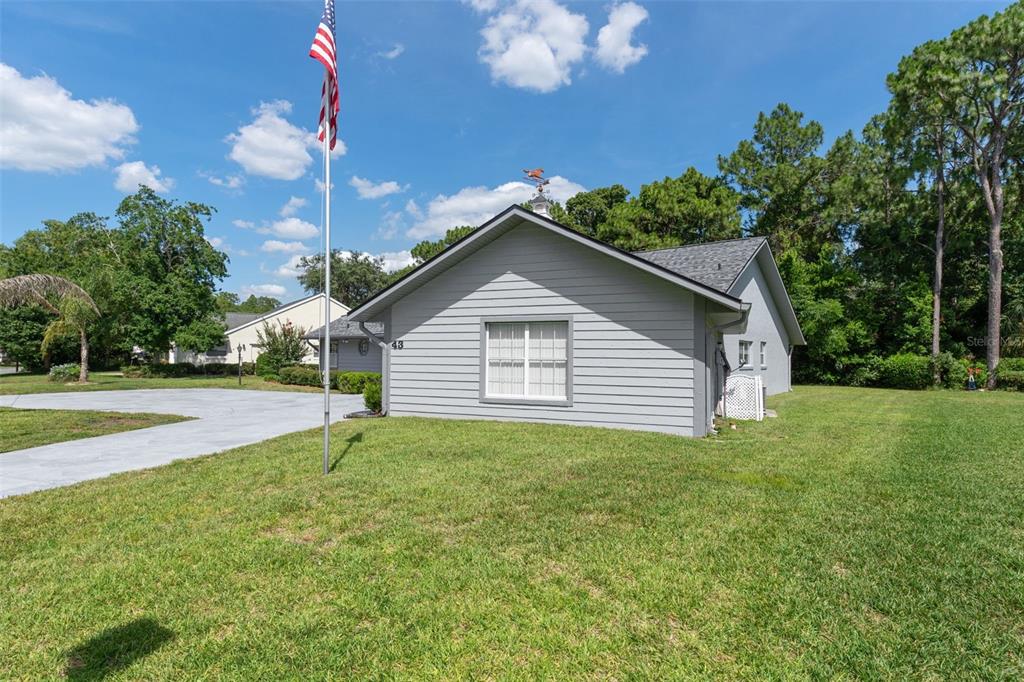 A single-story gray house with a stone-patterned driveway and a two-car garage — 43 LINDER CIRCLE, HOMOSASSA, FL