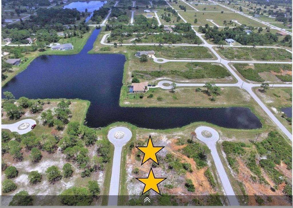 An aerial view shows two vacant lots marked with stars near a residential pond — 13 YARDARM DRIVE, PLACIDA, FL
