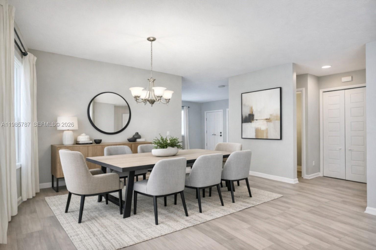 A dining room features a wooden table, six upholstered chairs, a sideboard, and a chandelier — 760 NE 193rd Ter, Miami FL 33179, MIAMI, FL