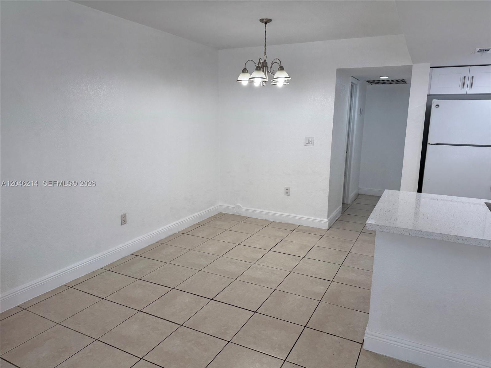 A dining area features white walls, tile flooring, and a hanging light fixture — 8695 NW 6th Ln # 105, Miami FL 33126, MIAMI, FL