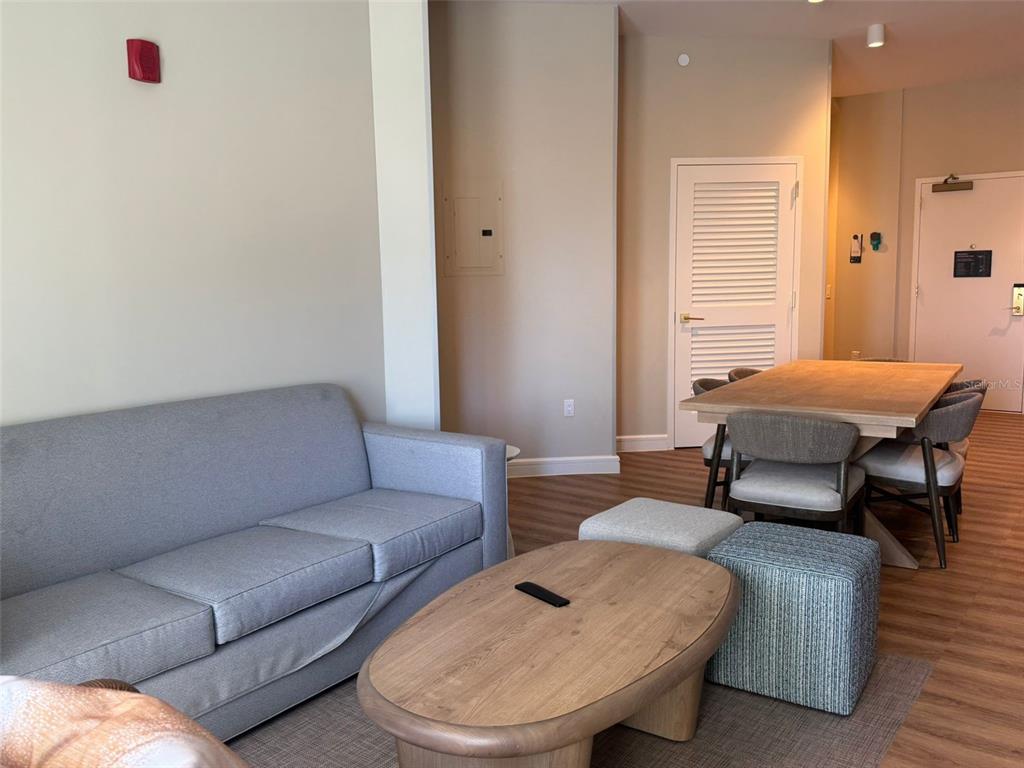 A living room features a gray sofa, a wooden coffee table, and a dining area — 3151 SUNSET WALK DRIVE UNIT 314, KISSIMMEE, FL