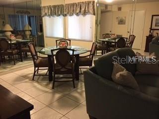 A dining area with a glass table and chairs sits adjacent to a living room — 5271 WILLOW LINKS UNIT 49, SARASOTA, FL