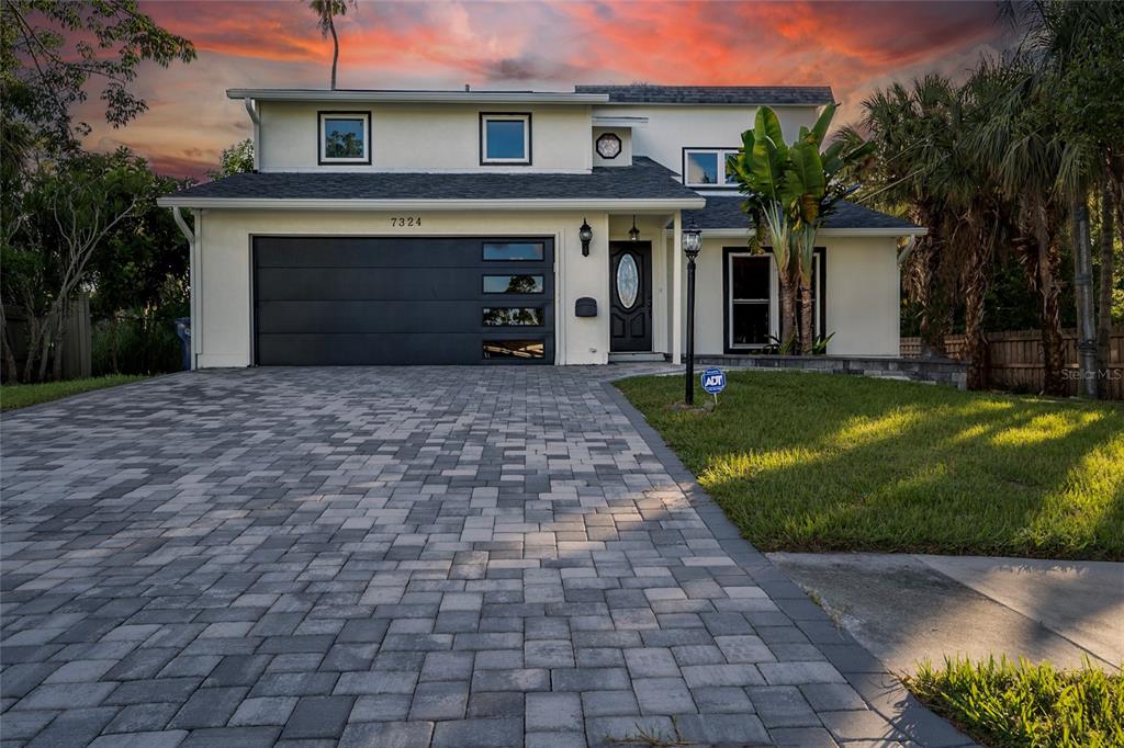A two-story house with a paved driveway, dark garage door, and a front entrance — 7324 PHILLIPS STREET, SARASOTA, FL