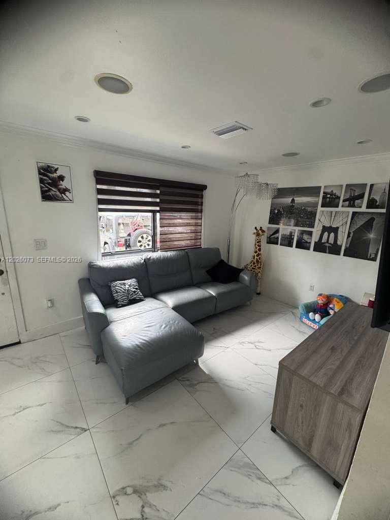 A living room features a gray sectional sofa, marble-look tile flooring, and wall-mounted city photography — 8430 NW 8th St # B11, Miami FL 33126, MIAMI, FL