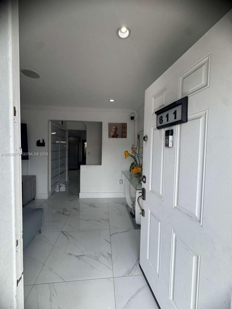 An entryway features white marble-look tile flooring and a white door with a house number — 8430 NW 8th St # B11, Miami FL 33126, MIAMI, FL