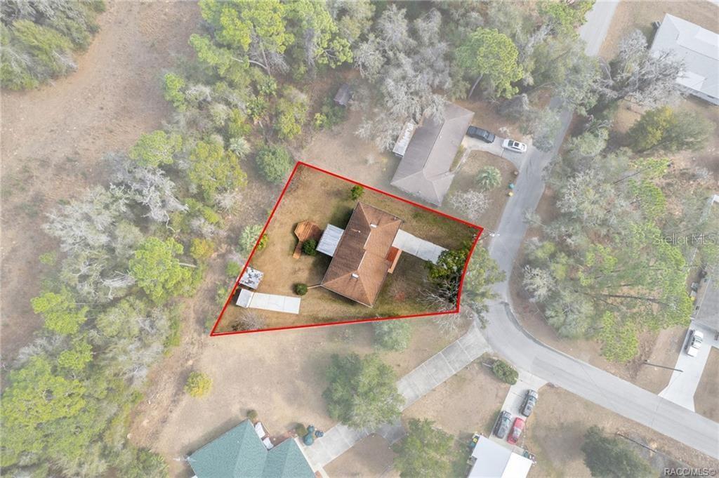 An aerial view shows a house with a brown roof on a triangular lot — 316 PEONY STREET, INVERNESS, FL