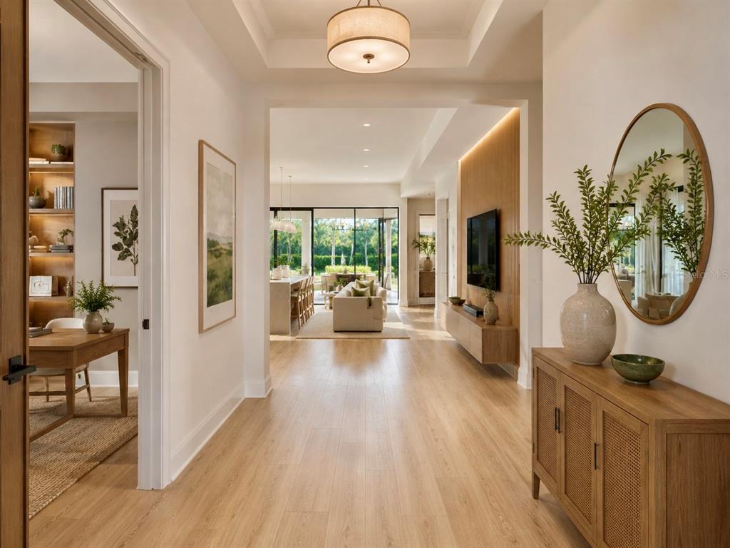 A bright foyer with light wood flooring leads into an open-concept living area and kitchen — 9613 KNOLLWOOD LANE, FORT PIERCE, FL