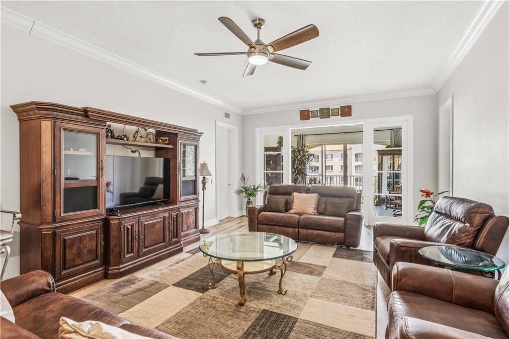 A living room features leather furniture, a large wooden entertainment center, and a glass coffee table — HUTCHINSON ISLAND, FL