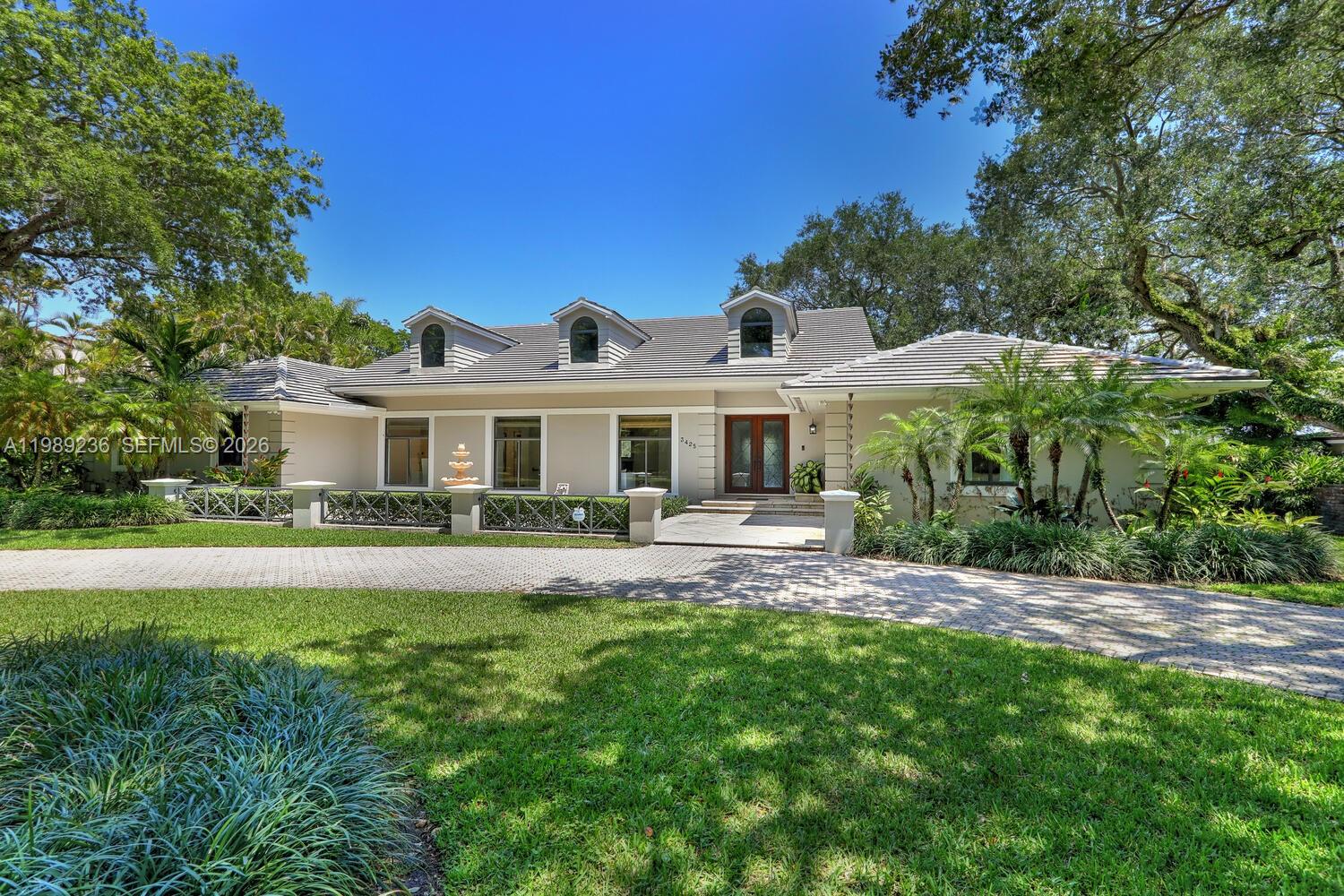 A single-story house with a gray tile roof and a paved circular driveway — 3425 Alhambra Cir, Coral Gables FL 33134, CORAL GABLES, FL