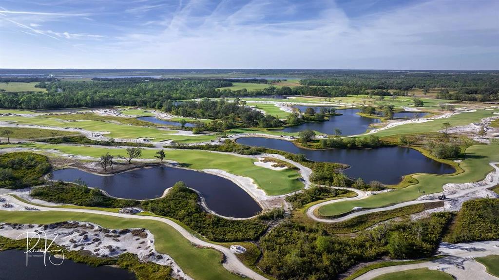 An aerial view of a golf course featuring multiple ponds, sand bunkers, and green fairways — 11149 PRICE LANE, MYAKKA CITY, FL