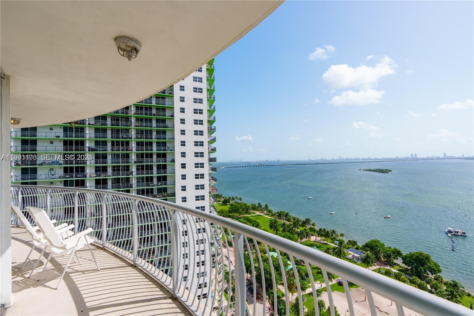 A high-rise balcony overlooks a bay, a park, and a neighboring apartment building — 1750 N Bayshore Dr # 2401, Miami FL 33132, MIAMI, FL