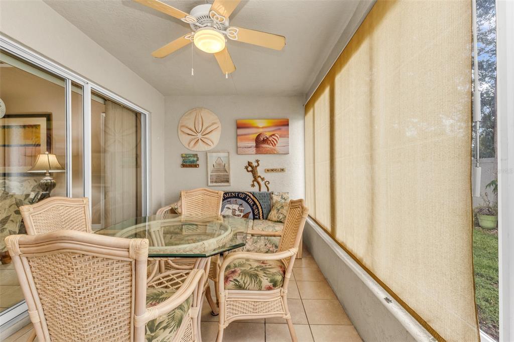 A sunroom features a glass-topped wicker dining set, a ceiling fan, and large windows — 24208 BUCKINGHAM WAY, PUNTA GORDA, FL