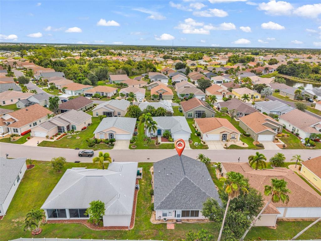 An aerial view shows a residential neighborhood with single-family homes and a marked property — 24208 BUCKINGHAM WAY, PUNTA GORDA, FL