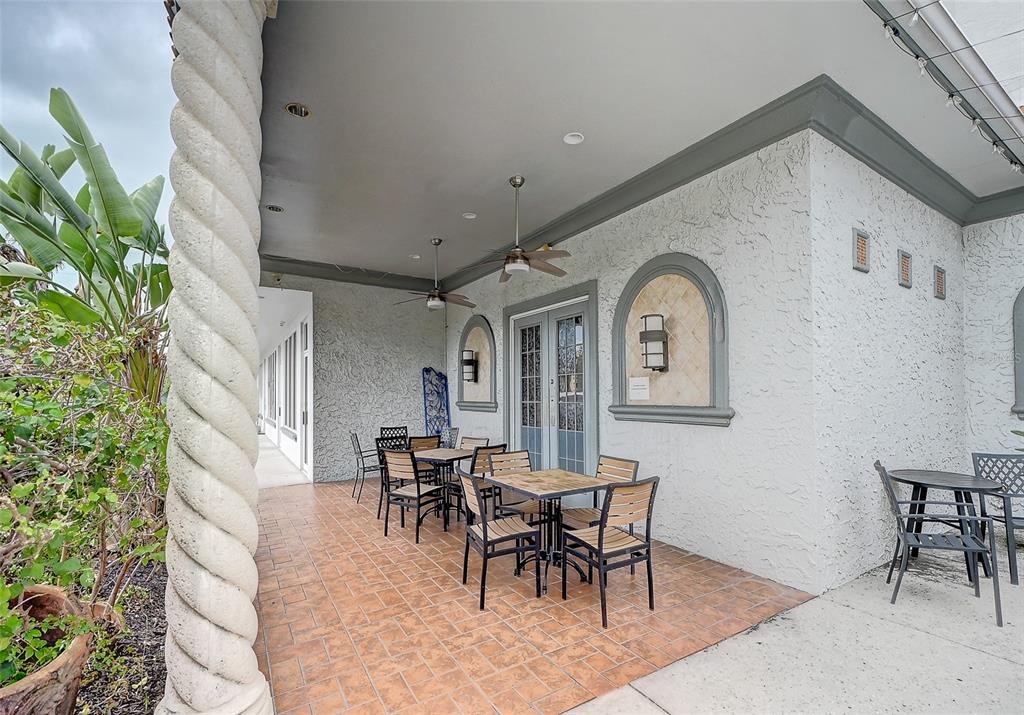 A covered outdoor patio features a spiral column, tiled flooring, and several dining sets — 8911 DANIELS PARKWAY UNIT 5, FORT MYERS, FL