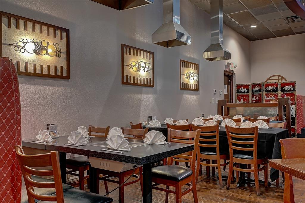 A restaurant dining room features multiple tables with folded napkins, wooden chairs, and overhead vents — 8911 DANIELS PARKWAY UNIT 5, FORT MYERS, FL