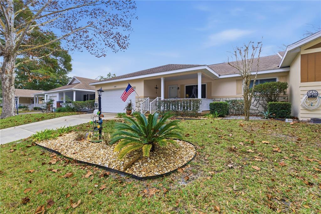 A single-story house with a stone facade, a front porch, and a landscaped yard — 8702 SW 94TH STREET UNIT E, OCALA, FL