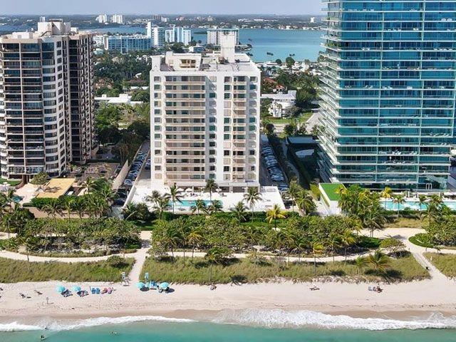An aerial view shows three tall residential buildings situated along a sandy beach — 10185 Collins Ave # 319, Bal Harbour FL 33154, BAL HARBOUR, FL