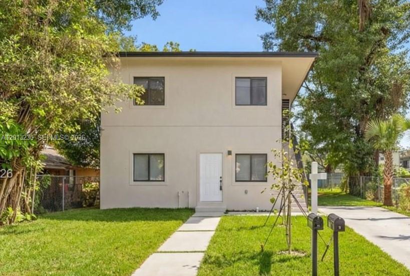 A two-story, light-colored stucco building with a front walkway and two mailboxes on the lawn — 1440 NW 61st St # 2, Miami FL 33142, MIAMI, FL