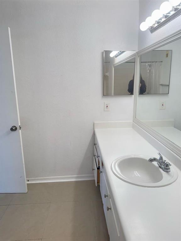 A bathroom features a white vanity with a single sink, a mirror, and tiled flooring — 3350 N Pinewalk Dr # 1426, Margate FL 33063, MARGATE, FL