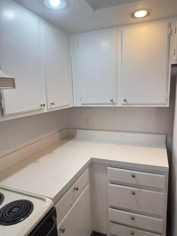 A kitchen corner features white cabinets, a white countertop, and a white electric stove — 3350 N Pinewalk Dr # 1426, Margate FL 33063, MARGATE, FL