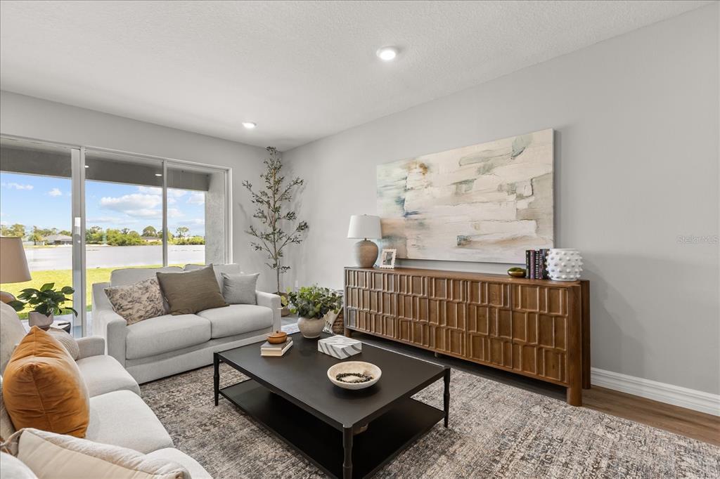 A living room features a sofa, coffee table, wooden console, and a view of water — 25 FREESIA COURT, HOMOSASSA, FL