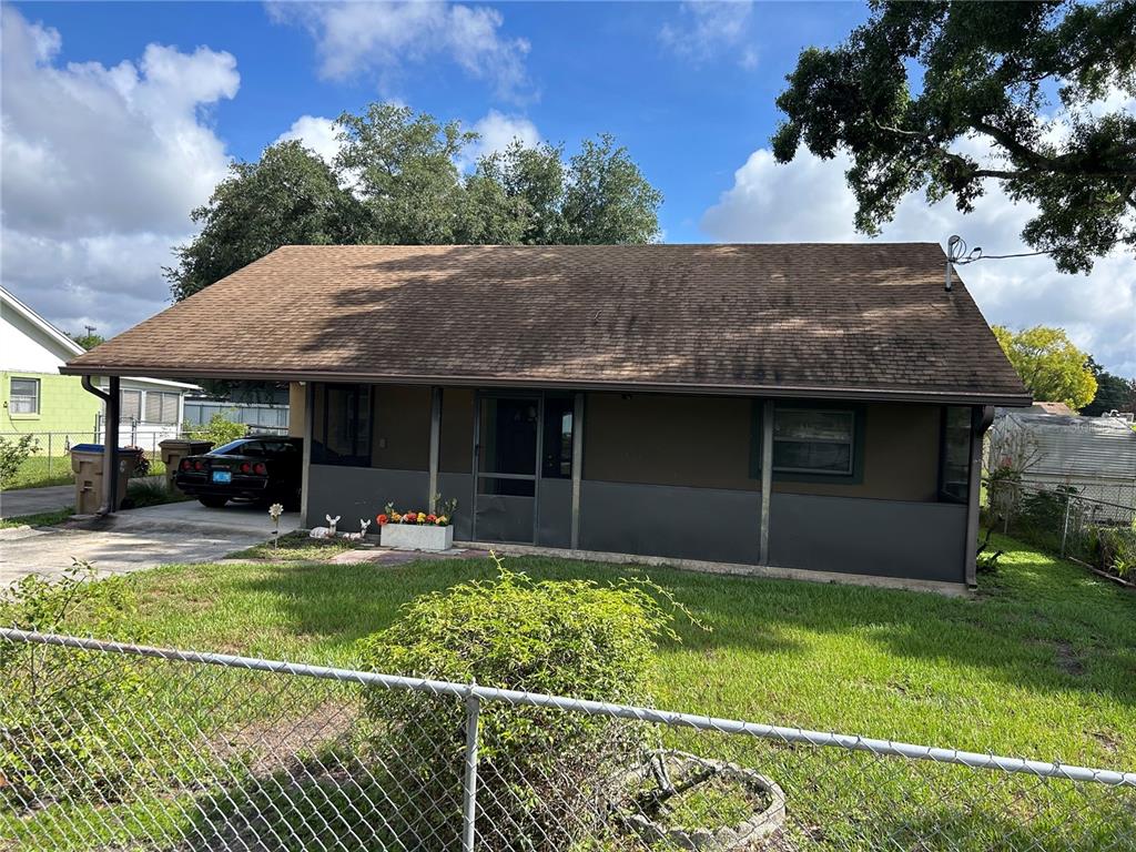 A single-story house with a brown roof, dark exterior walls, and a front porch — 1213 CHEROKEE DRIVE, KISSIMMEE, FL