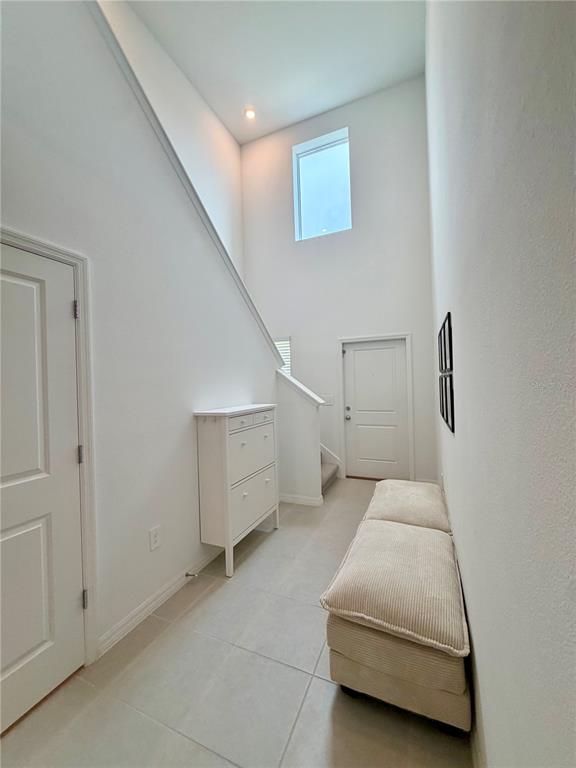 An entryway features a high ceiling, tiled floors, a white shoe cabinet, and a bench — 7727 ABAGAIL DRIVE, LAKELAND, FL