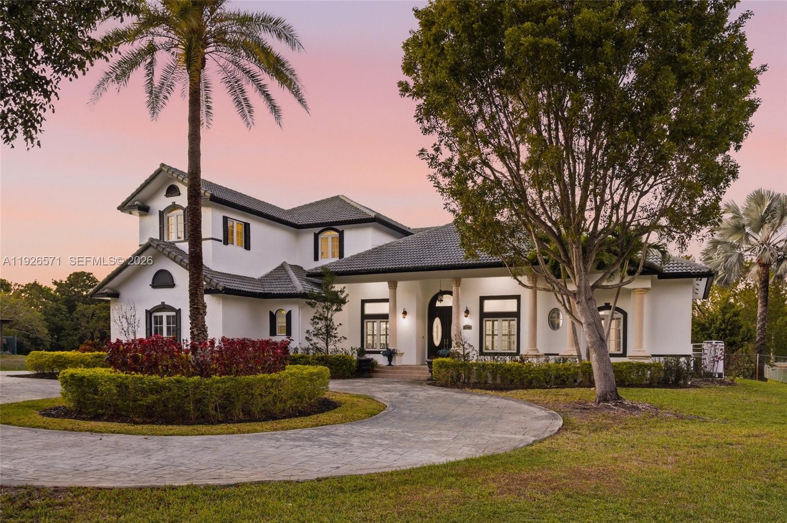 A two-story white house with a dark tile roof and a circular stone driveway — 20401 SW 48th Pl, Southwest Ranches FL 33332, SOUTHWEST RANCHES, FL
