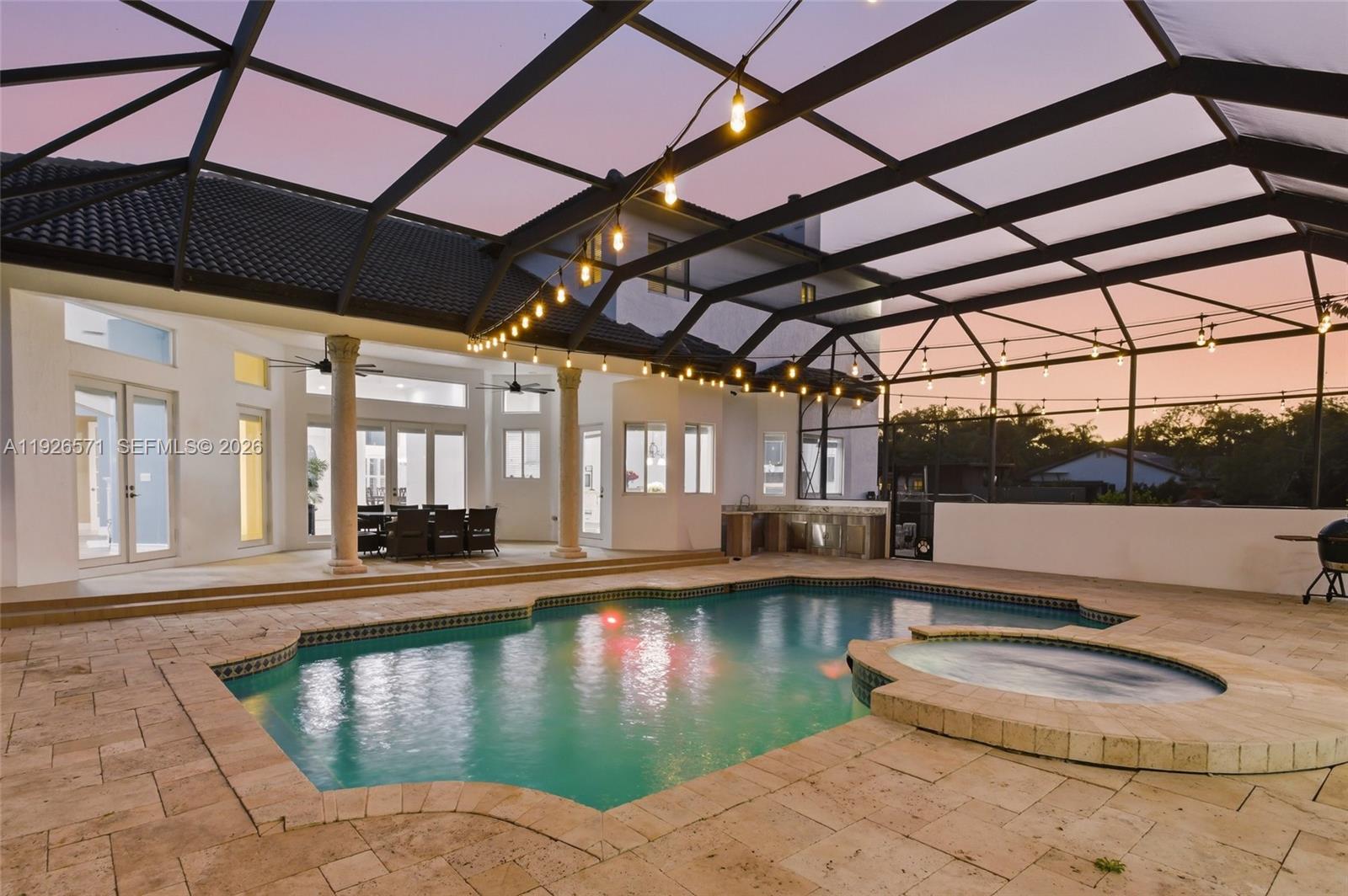 A screened-in patio features a swimming pool, a hot tub, and an outdoor kitchen area — 20401 SW 48th Pl, Southwest Ranches FL 33332, SOUTHWEST RANCHES, FL