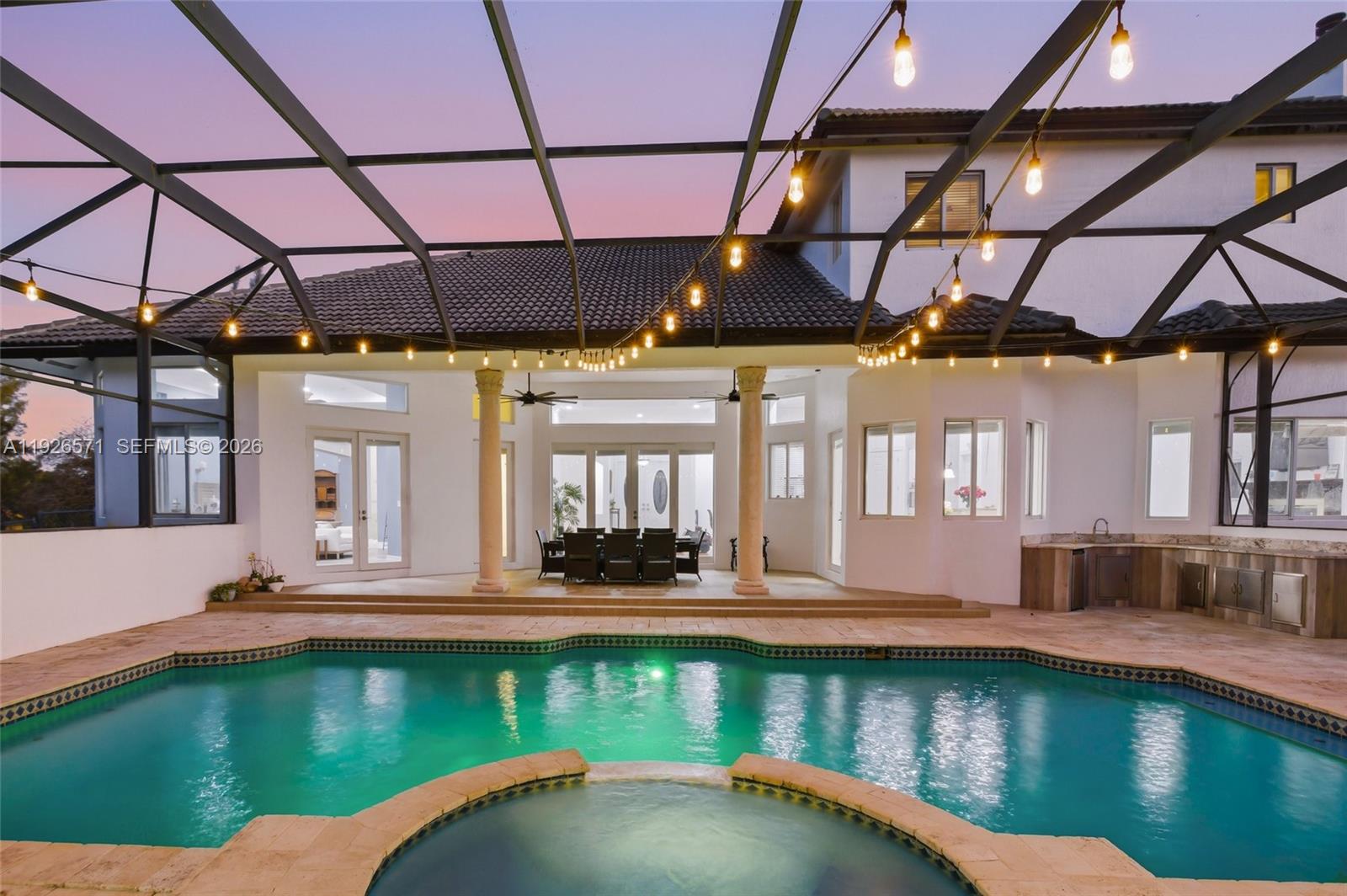 A covered patio with a pool and hot tub features string lights and outdoor seating — 20401 SW 48th Pl, Southwest Ranches FL 33332, SOUTHWEST RANCHES, FL