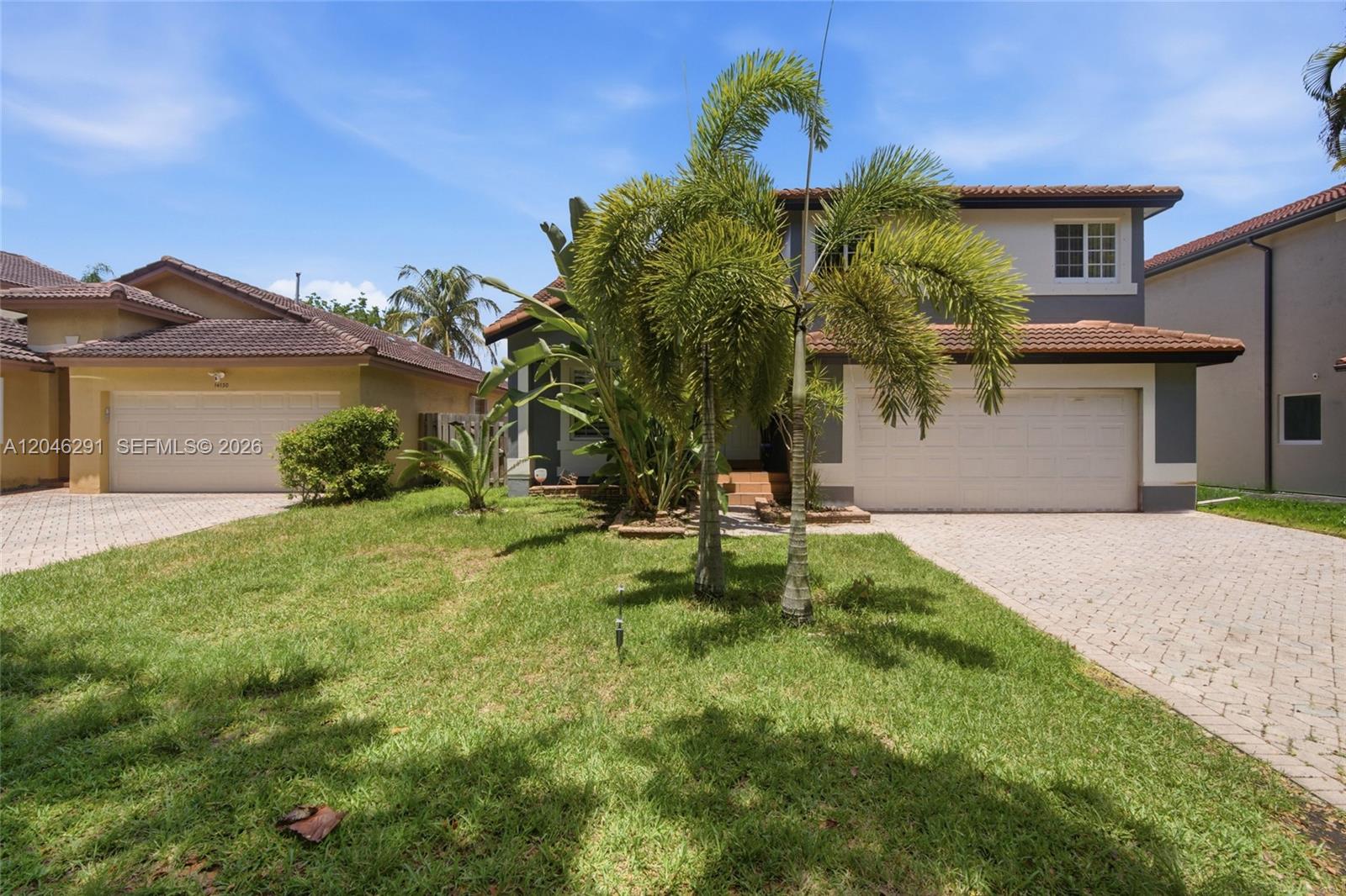 A two-story house with a tiled roof, a two-car garage, and a front lawn — 14110 SW 122nd Ct, Miami FL 33186, MIAMI, FL