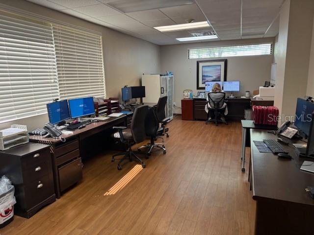 An office space features multiple desks, computer workstations, wood-look flooring, and window blinds — 610 JASMINE ROAD, ALTAMONTE SPRINGS, FL