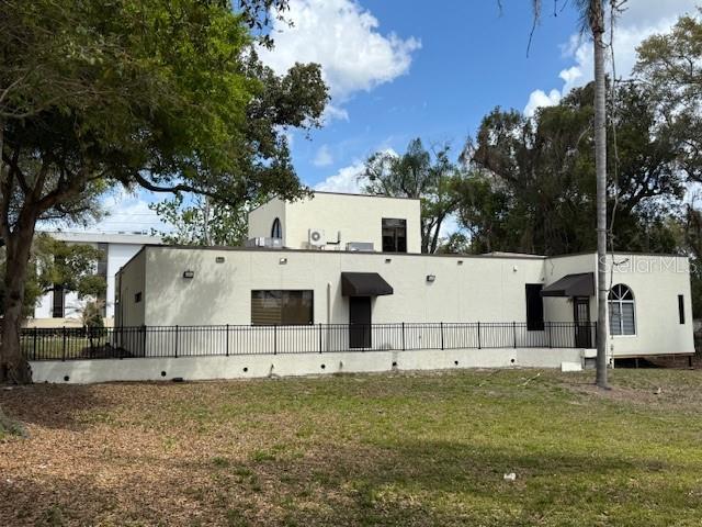 A single-story, light-colored commercial building with a flat roof and a black metal fence — 610 JASMINE ROAD, ALTAMONTE SPRINGS, FL