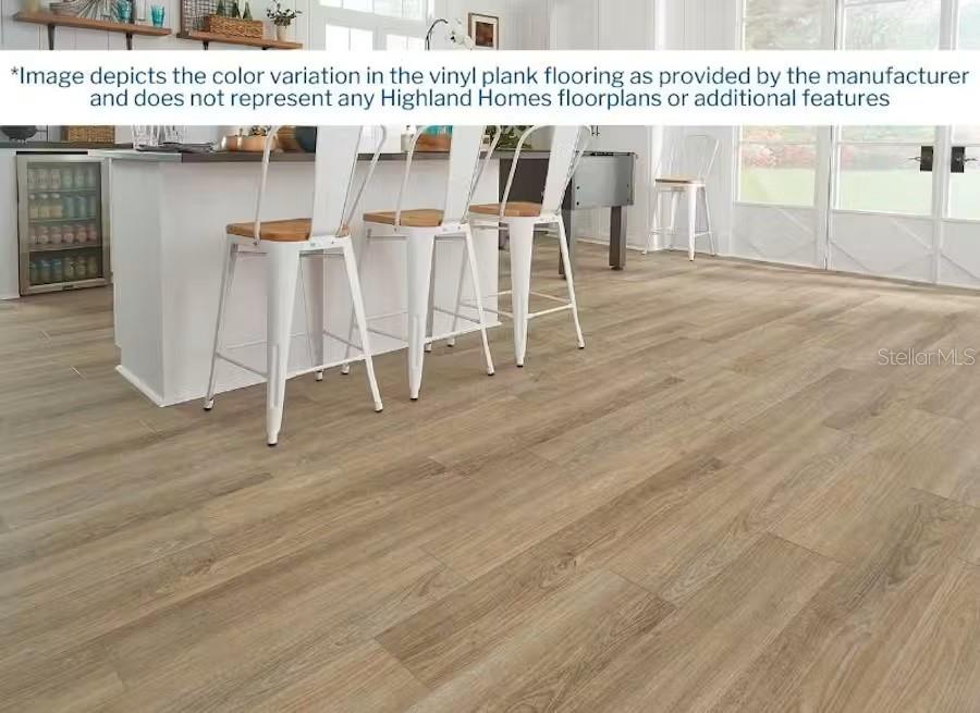 A kitchen island with three white stools sits on light wood-look vinyl plank flooring — 4041 KINDLING WOOD WAY, ST CLOUD, FL