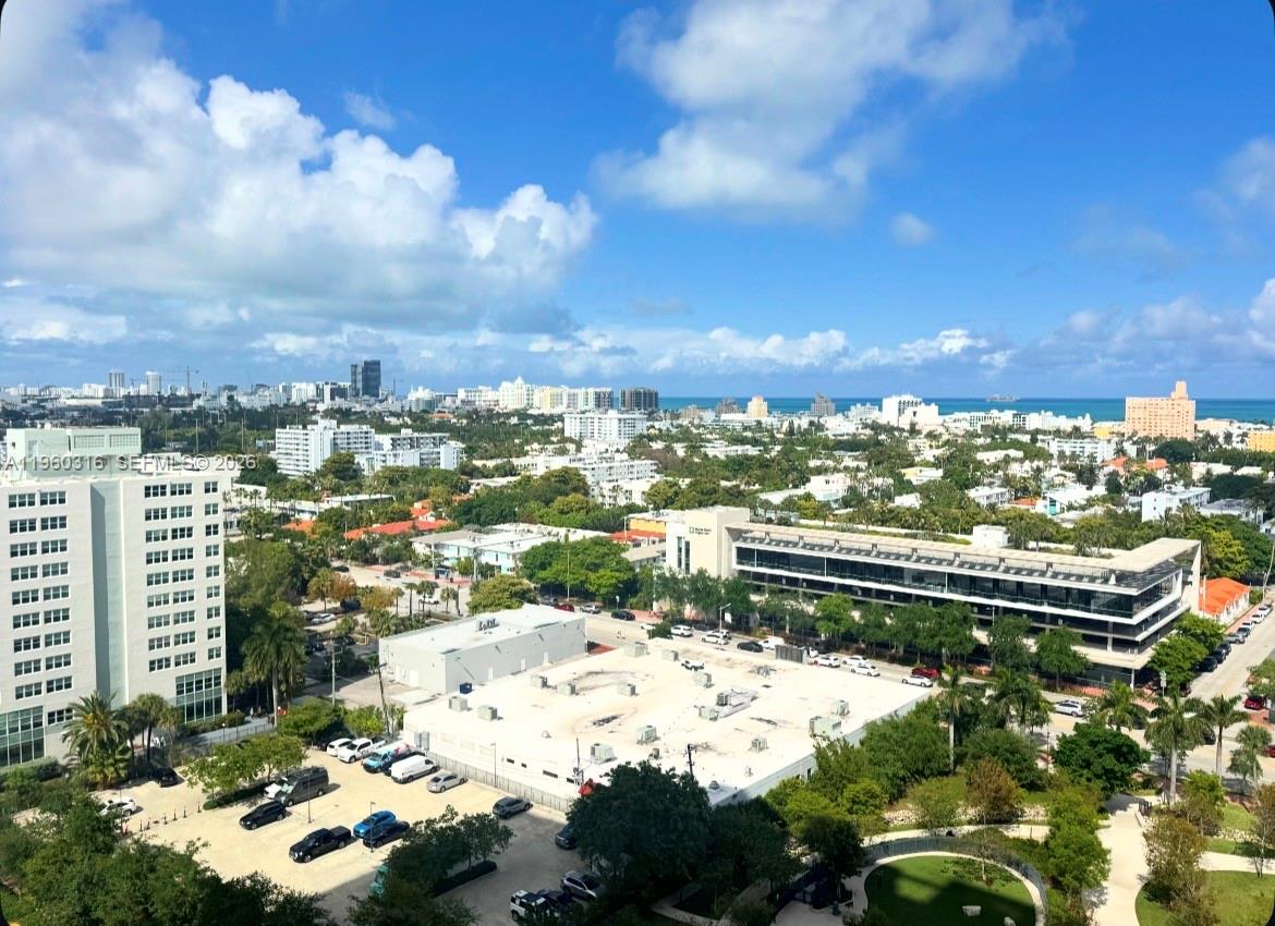An elevated outdoor view shows a city landscape with buildings, trees, and the ocean beyond — 650 West Ave # 1704, Miami Beach FL 33139, MIAMI BEACH, FL