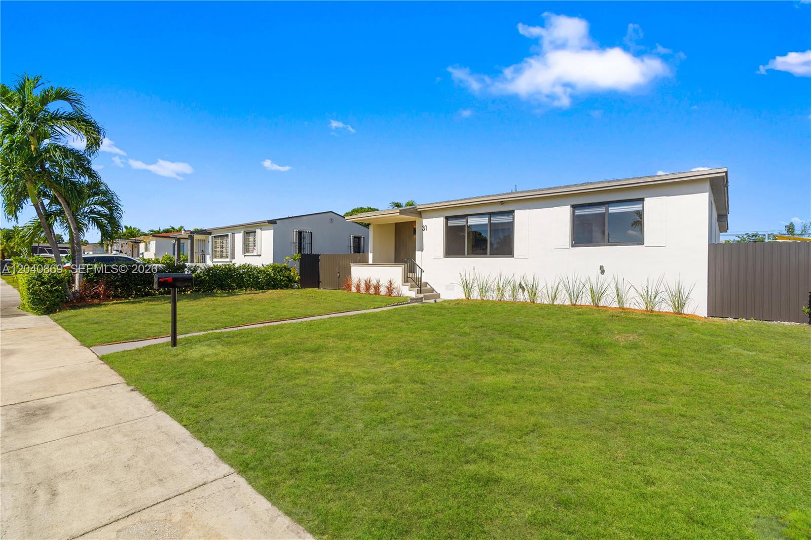 A single-story house with a beige exterior, a front walkway, and a grassy lawn — 31 W 64th St, Hialeah FL 33012, HIALEAH, FL